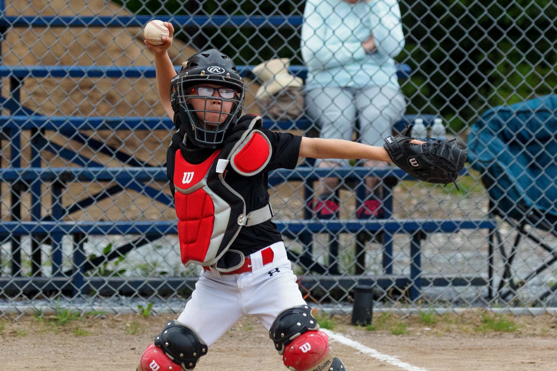 Child umpire throwing the baseball.