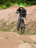 Boy riding bike through dirt mounds and hills.
